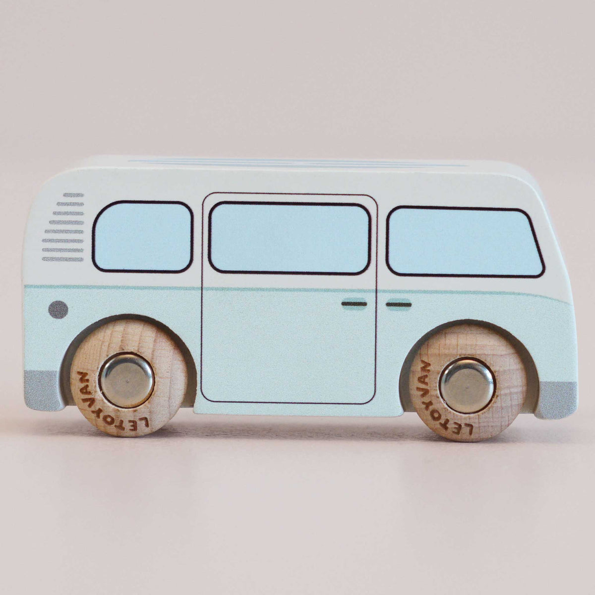 Le Toy Van Toy bus with light blue body and wooden wheels on a beige background