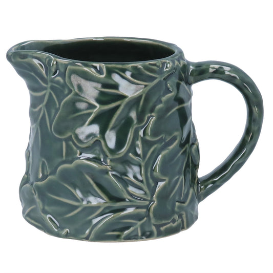 Green ceramic mug with leaf pattern on a white background