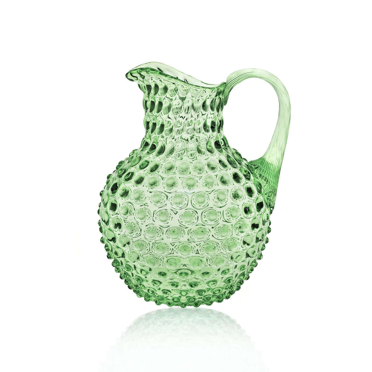 Green glass pitcher with textured surface on a white background